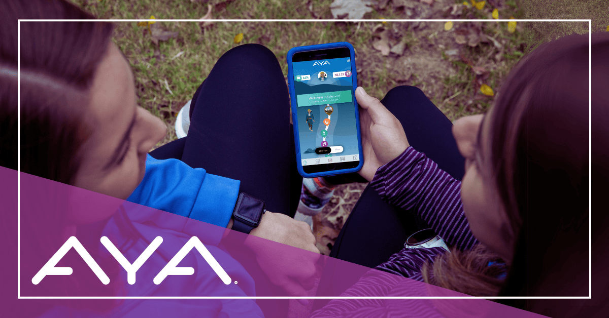 Two women sitting outdoors, viewing a smart phone with AYA Walk App journey open on the screen.