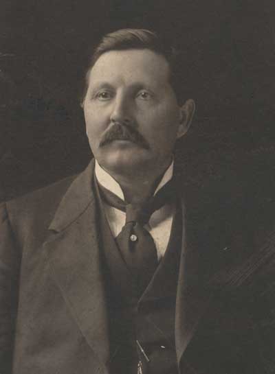Formal portrait of Douglas Johnston in a three piece suit.