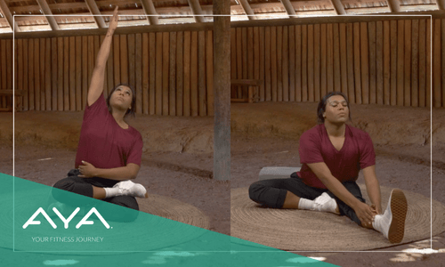 Three images of a person demonstrating yoga poses in front of a traditional Chickasaw grass house: a seated pose, an upward stretch, and a side bend. All wearing burgundy. AYA logo overlaid on teal diagonal with tagline 'Your Fitness Journey.
